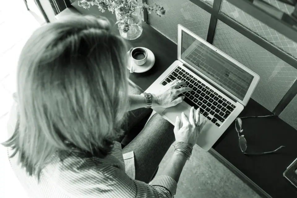 An administrator working at a laptop with notes beside them